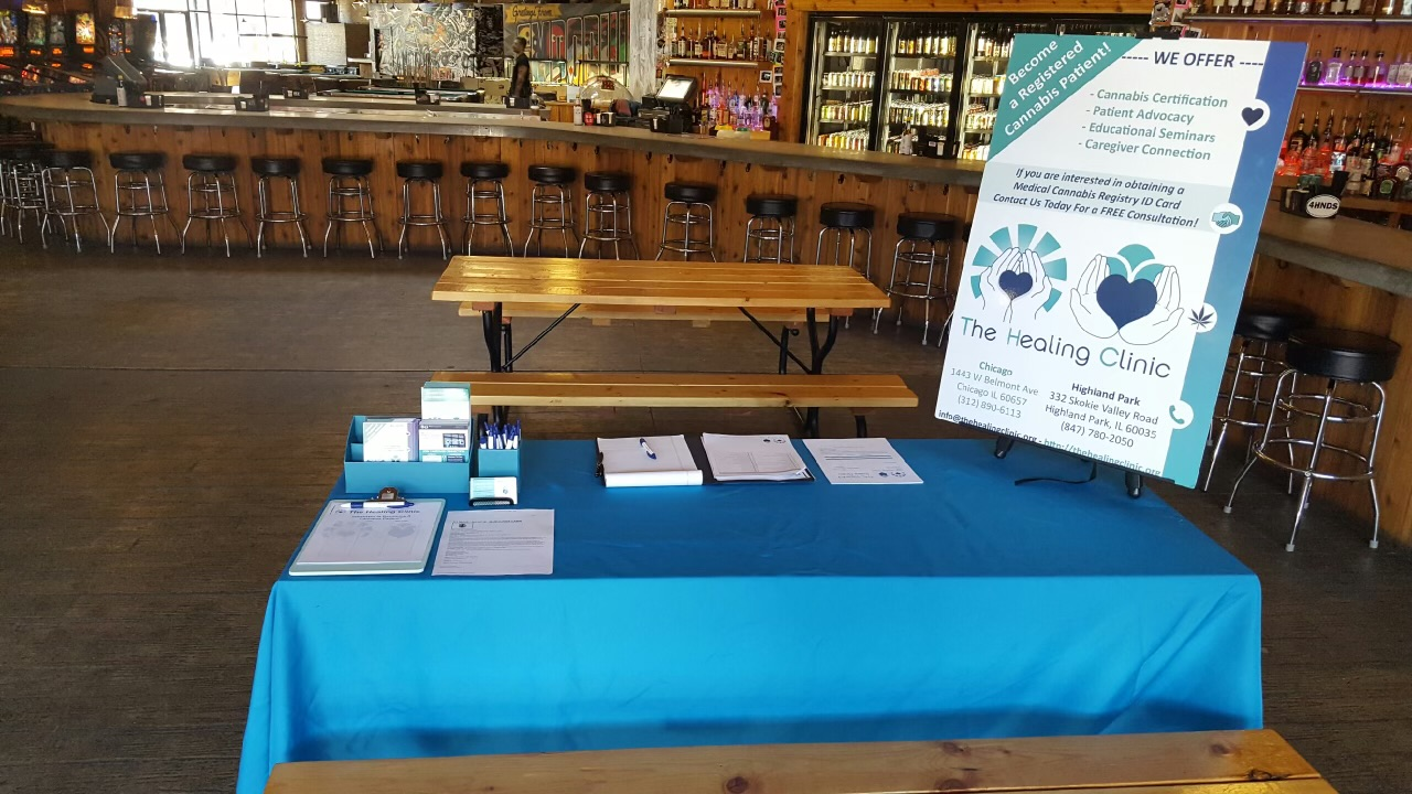 The Healing Clinic outreach table with brochures, clipboards, pens and an informational display.